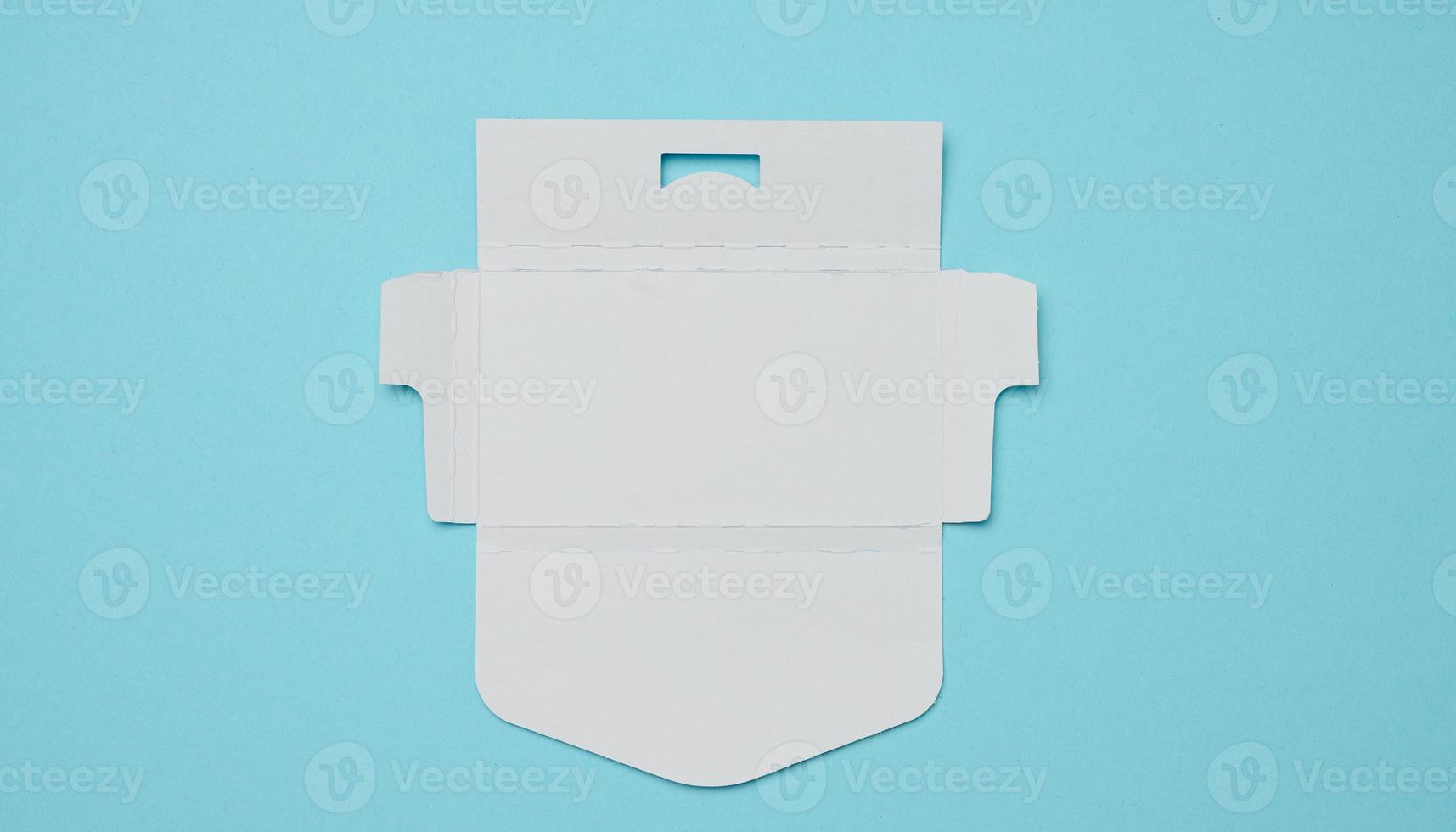 Unfolded white cardboard box on a blue background, top view photo