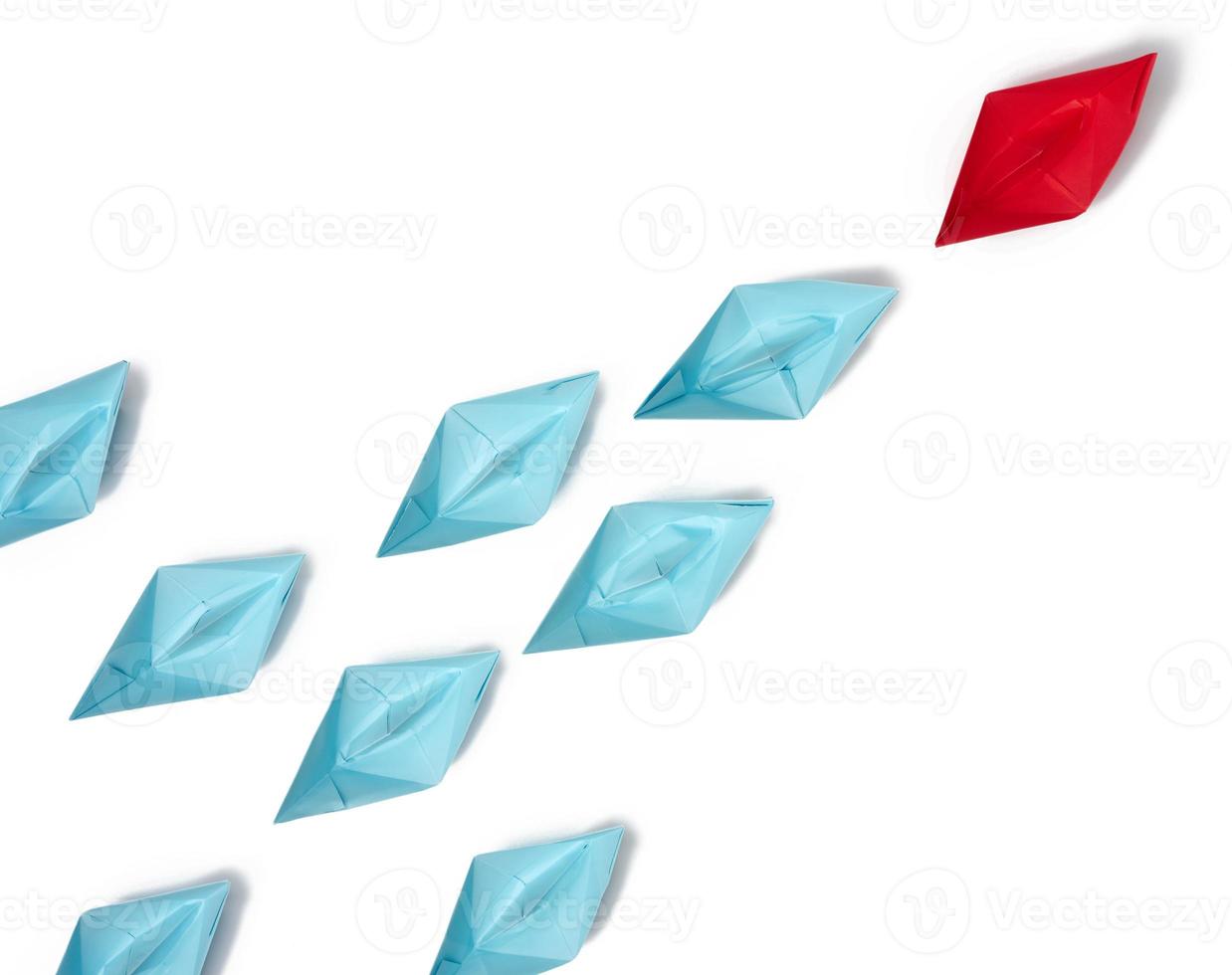 Group of paper boats on a white background. concept of a strong leader in a team, manipulation of the masses photo