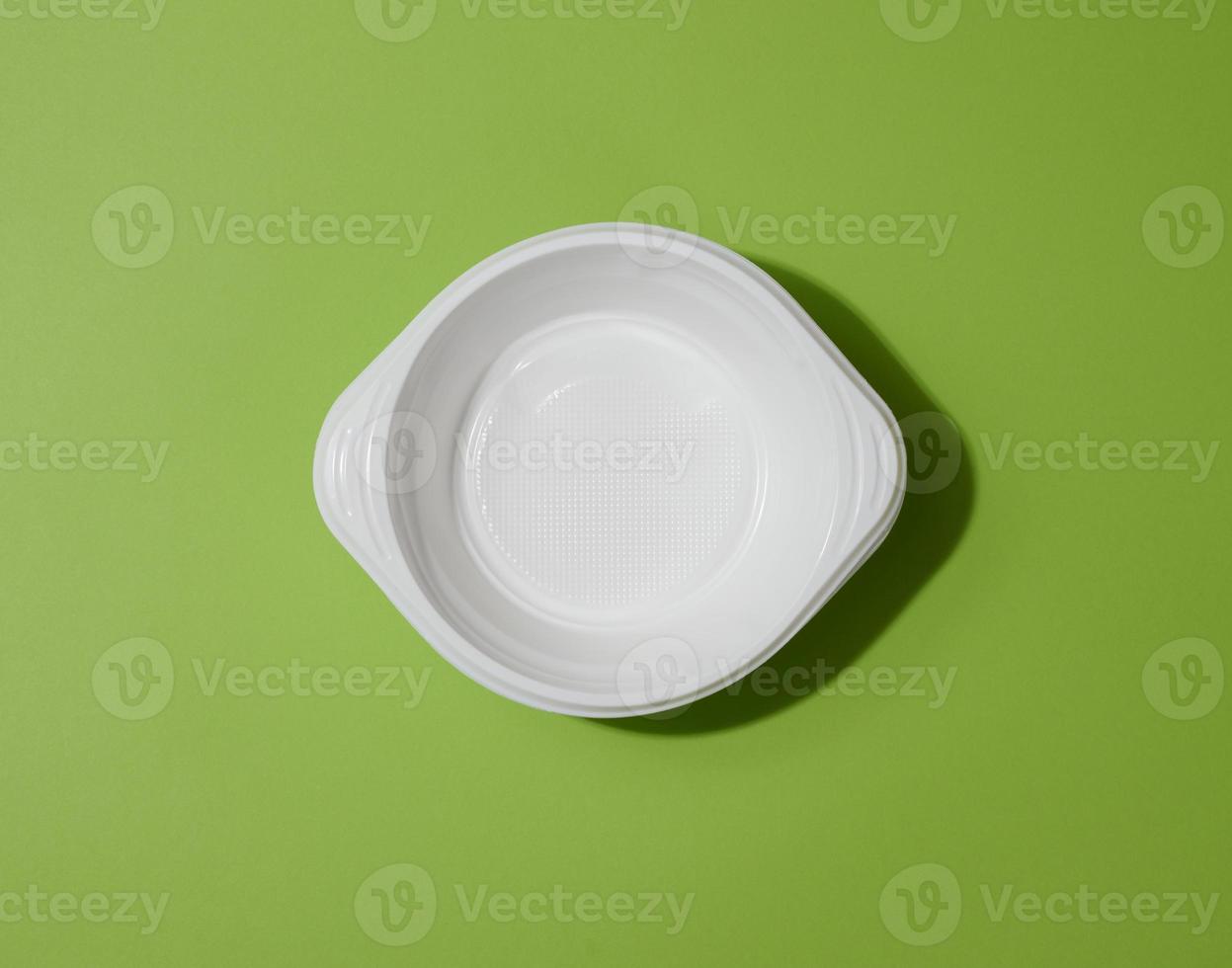 White empty plastic soup bowl on green background, top view photo