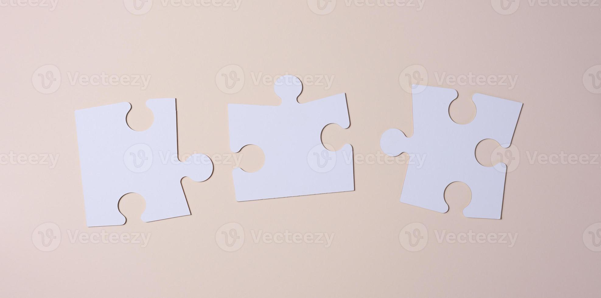Empty white big puzzles on a beige background. Concept in business photo