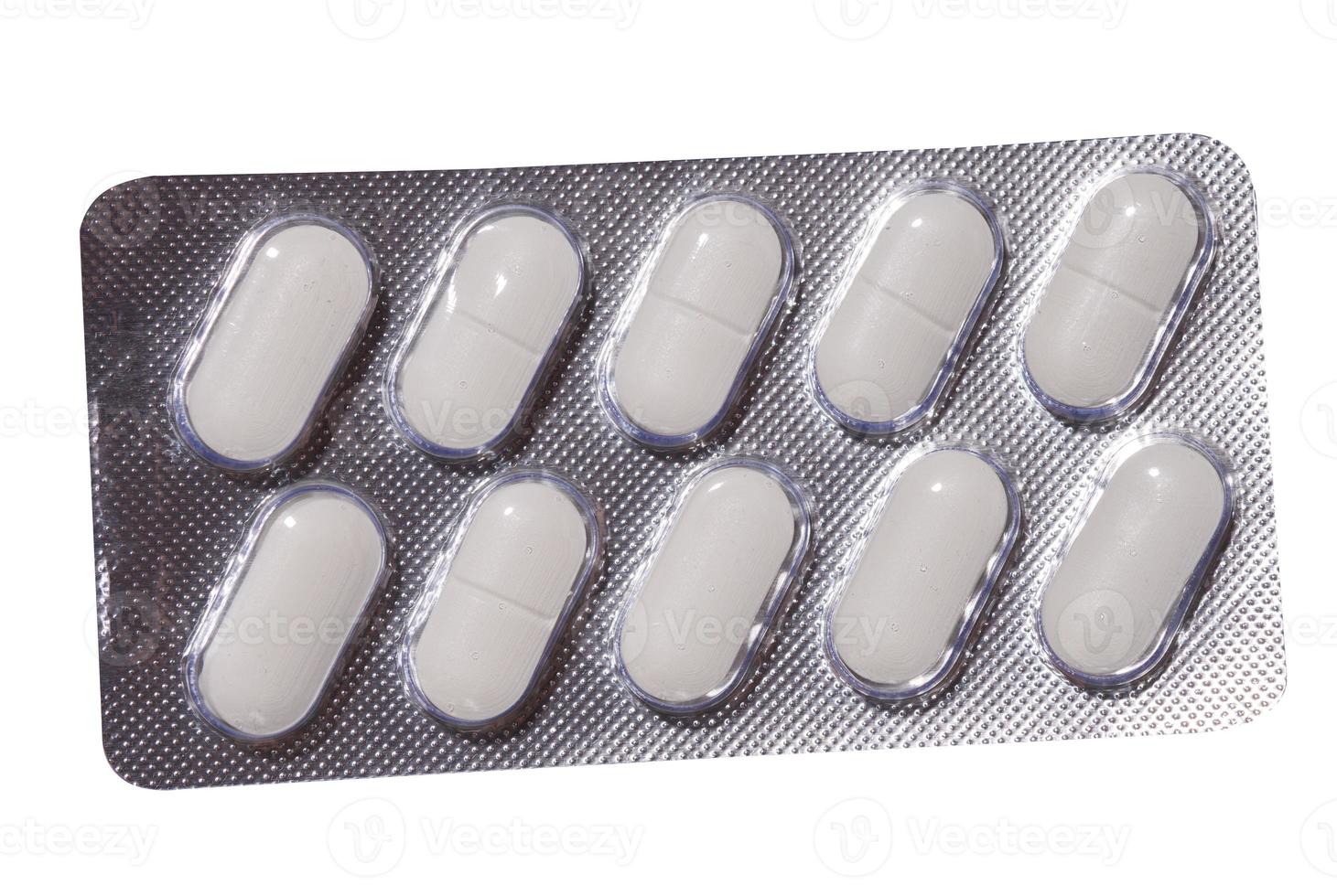 Oval white pills in a gray blister pack on a white background photo