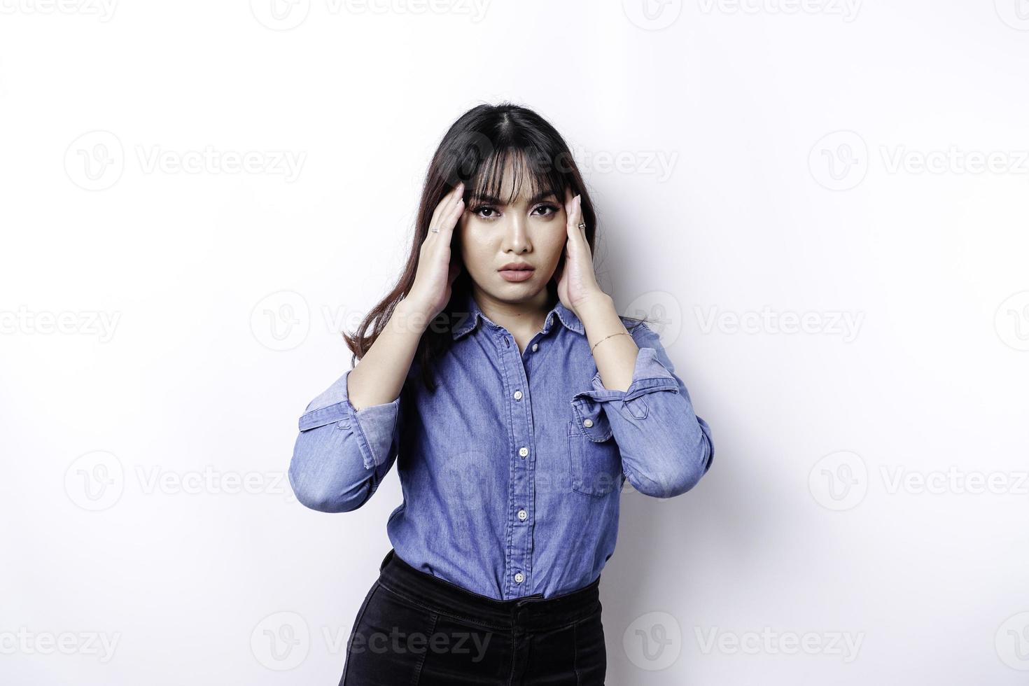 un retrato de una mujer asiática con un pantalones azul aislado de fondo blanco parece deprimido foto