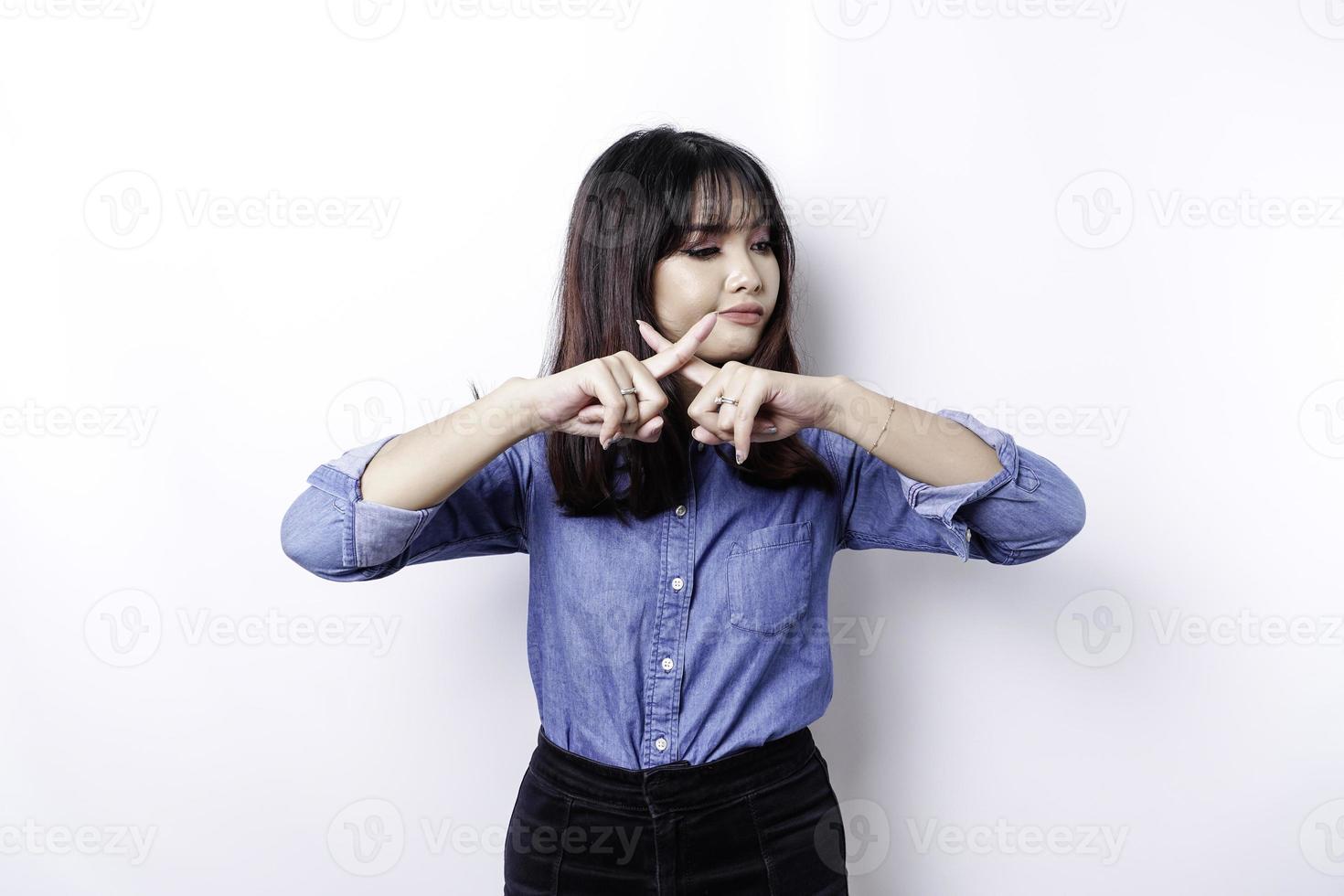 Beautiful Asian woman wearing blue shirt with hand gesture pose rejection or prohibition with copy space photo