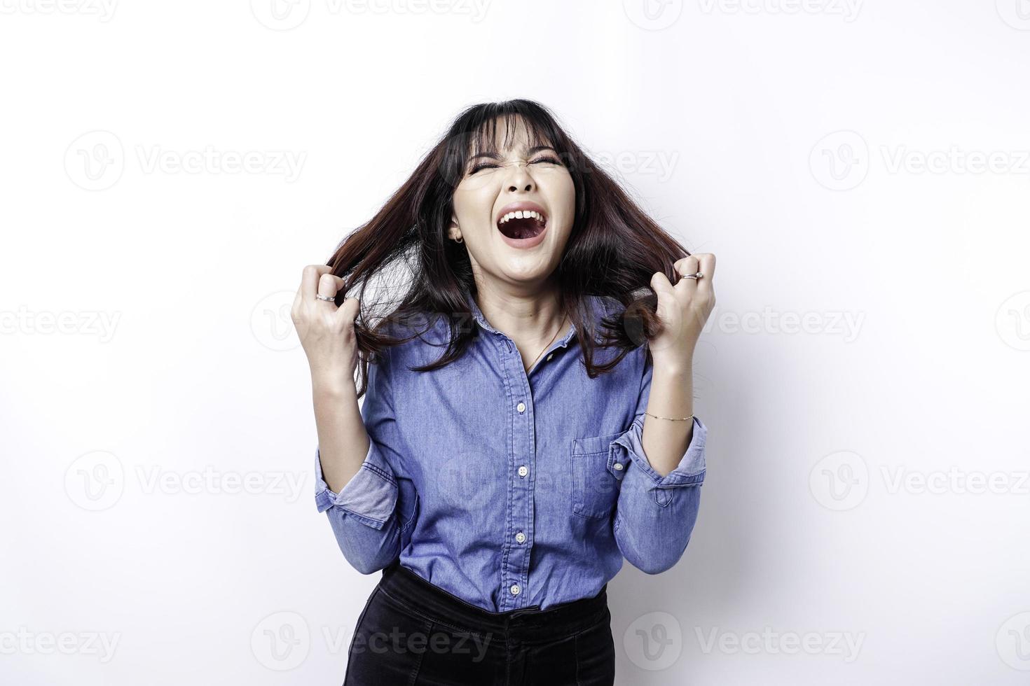 A portrait of an Asian woman wearing a blue shirt isolated by white background looks depressed photo