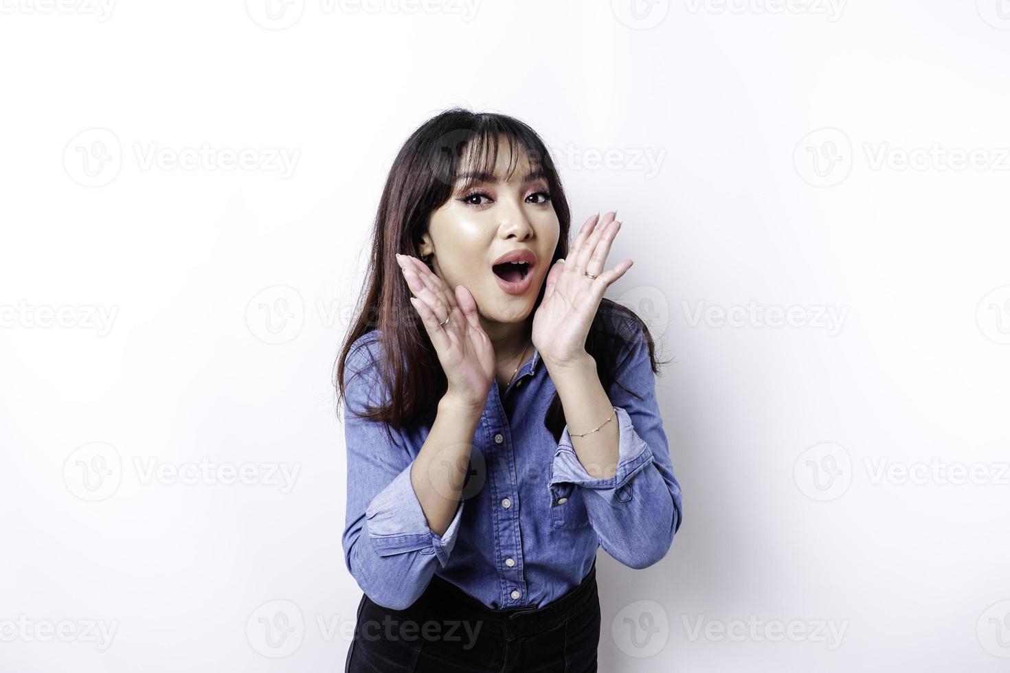Young beautiful woman wearing a blue shirt shouting and screaming loud with a hand on her mouth. communication concept. photo