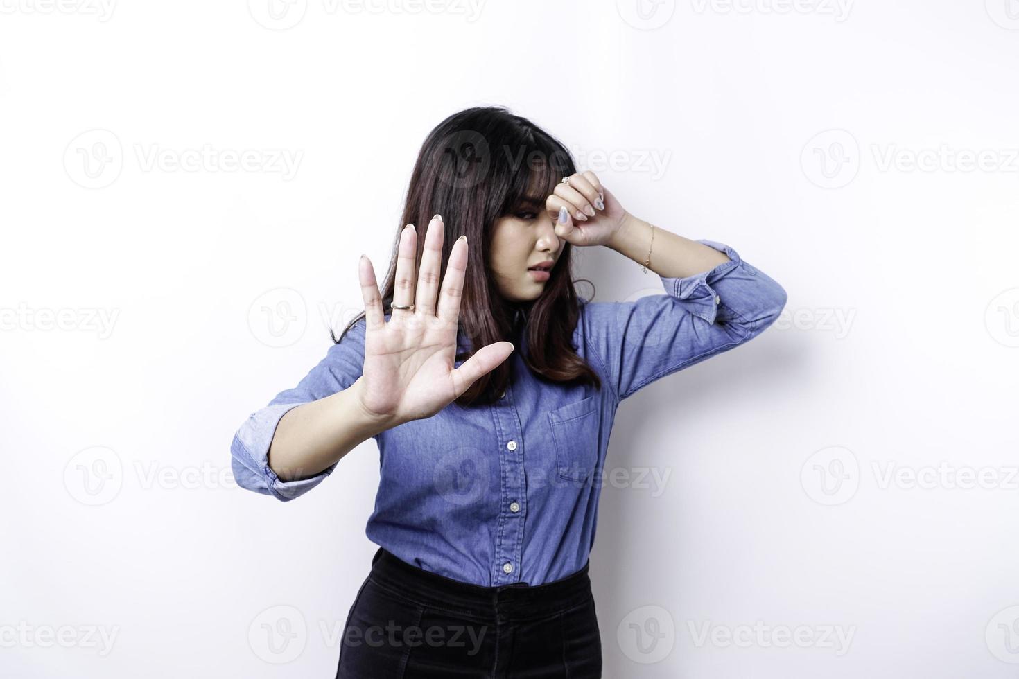 joven asiática aislada de fondo blanco, se ve deprimida, con la cara cubierta por los dedos, asustada y nerviosa. foto
