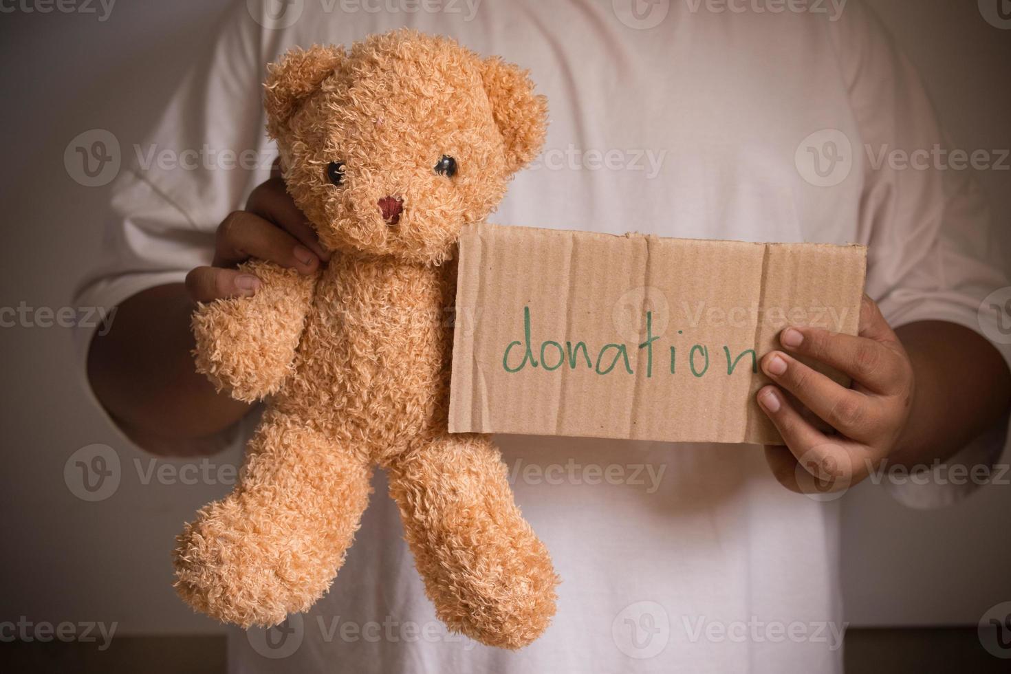 Male hand holding teddy bear for donation photo