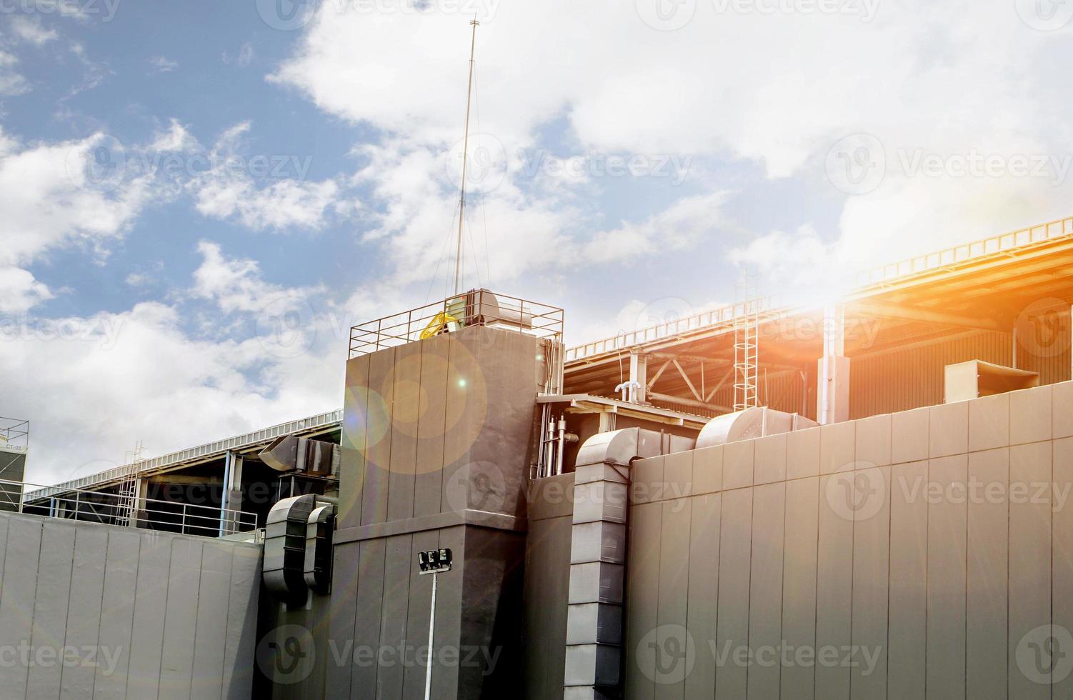 Exhaust and air conditioner ducts for support factory building under the bright of sun and blue sky. photo