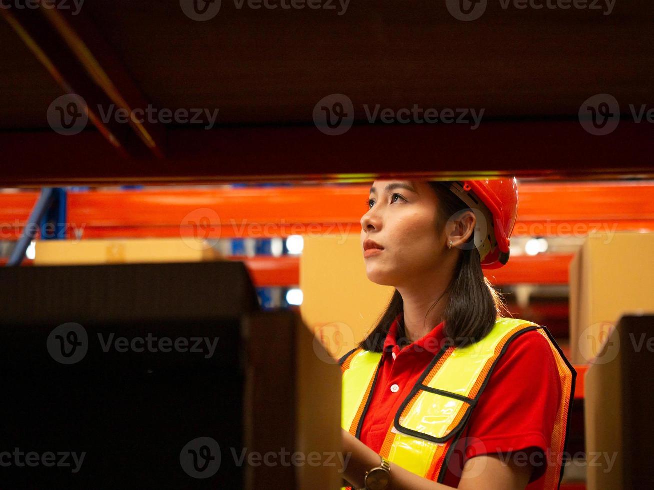 Female person orange red hardhat color helmet safety uniform factory industry warehouse shipping box import export woman people check up tablet shelf storage business distribution manager project site photo