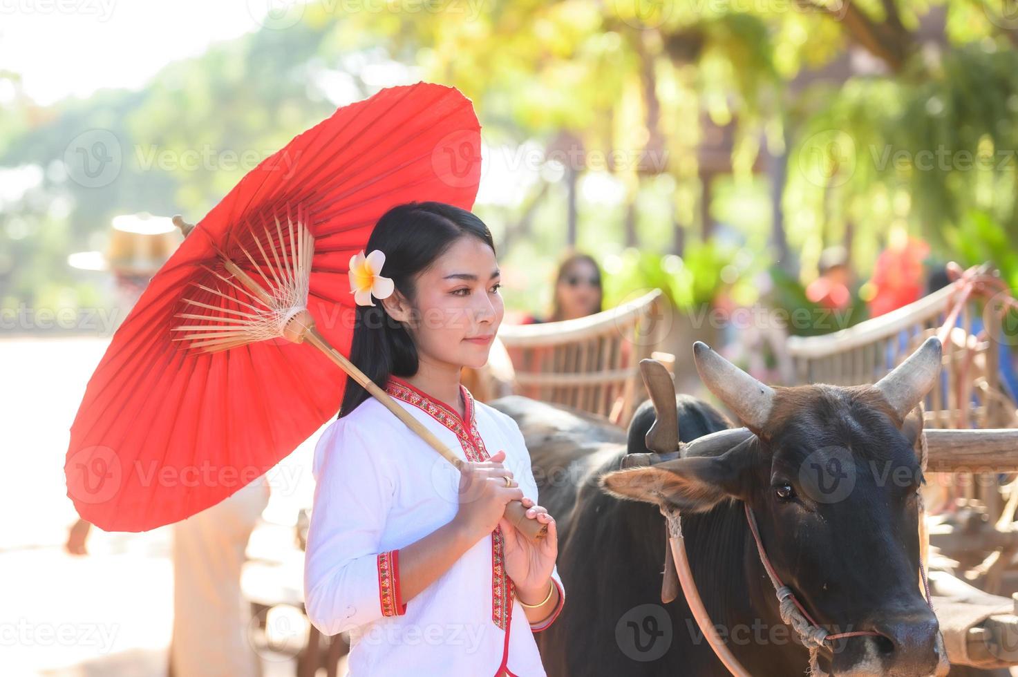 Asian woman wearing typical thai dress with red umbrella.,Thai costume photo