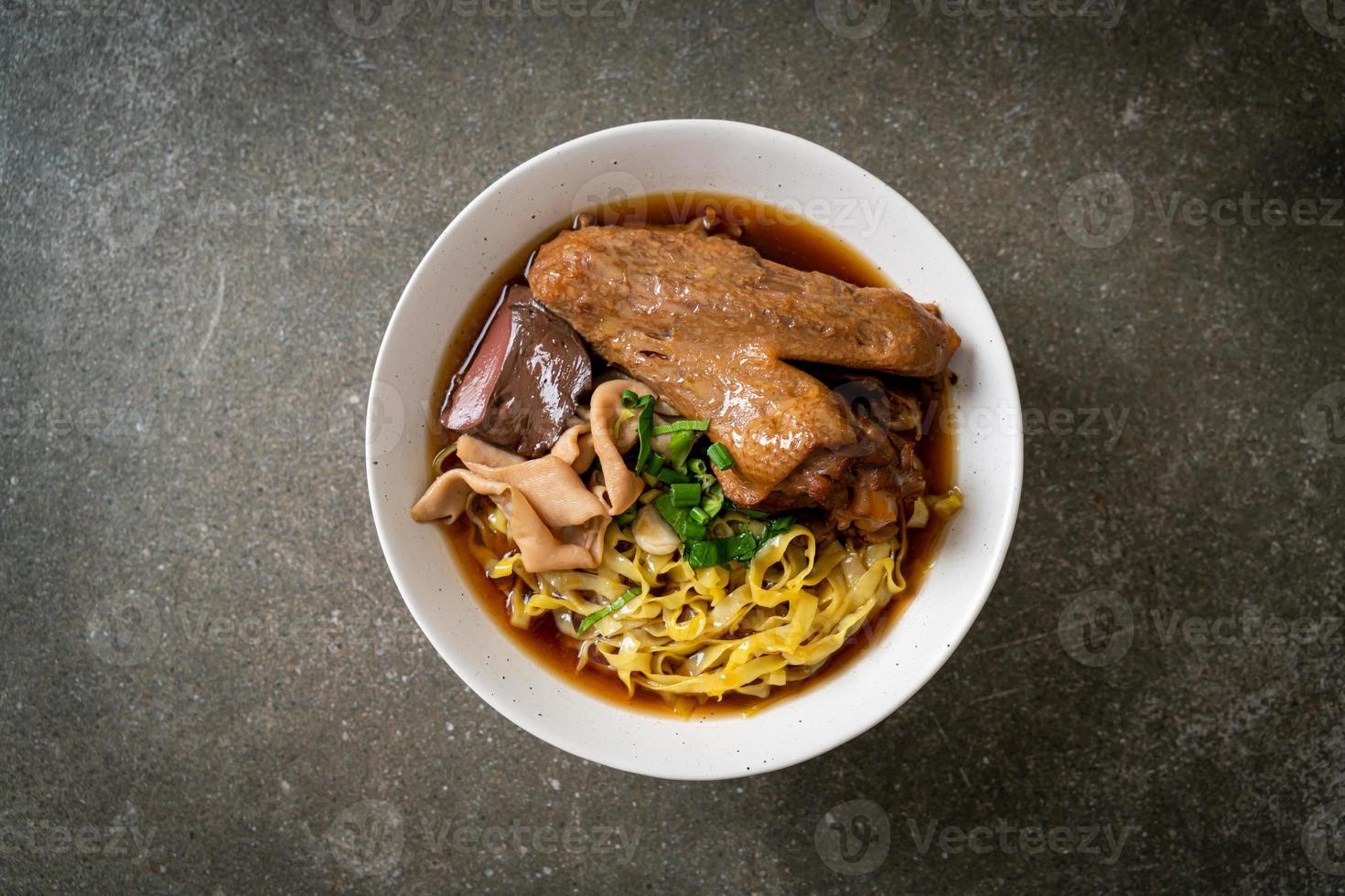 egg noodles with stewed and braised duck in brown soup photo