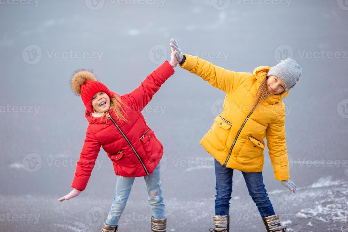 Adorable little girls skating on the ice-rink photo