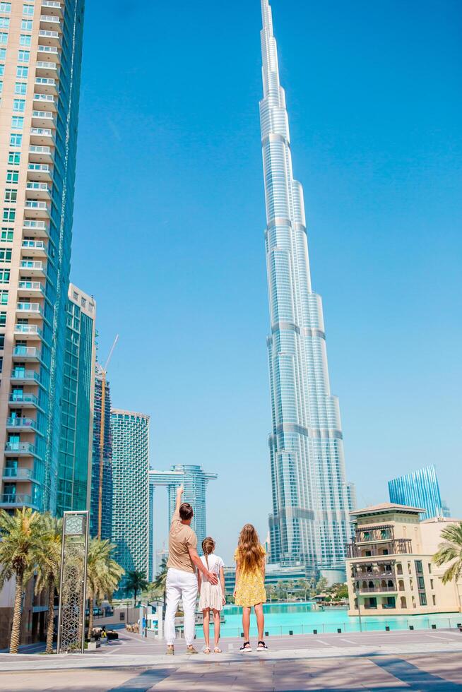 Happy family walking in Dubai with Burj Khalifa skyscraper in the background. photo