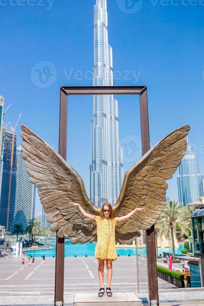 Happy girl walking in Dubai with skyscrapers in the background. photo