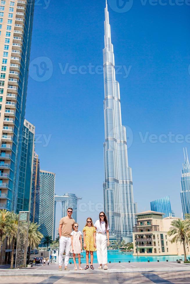 familia feliz caminando en dubai con rascacielos en el fondo. foto