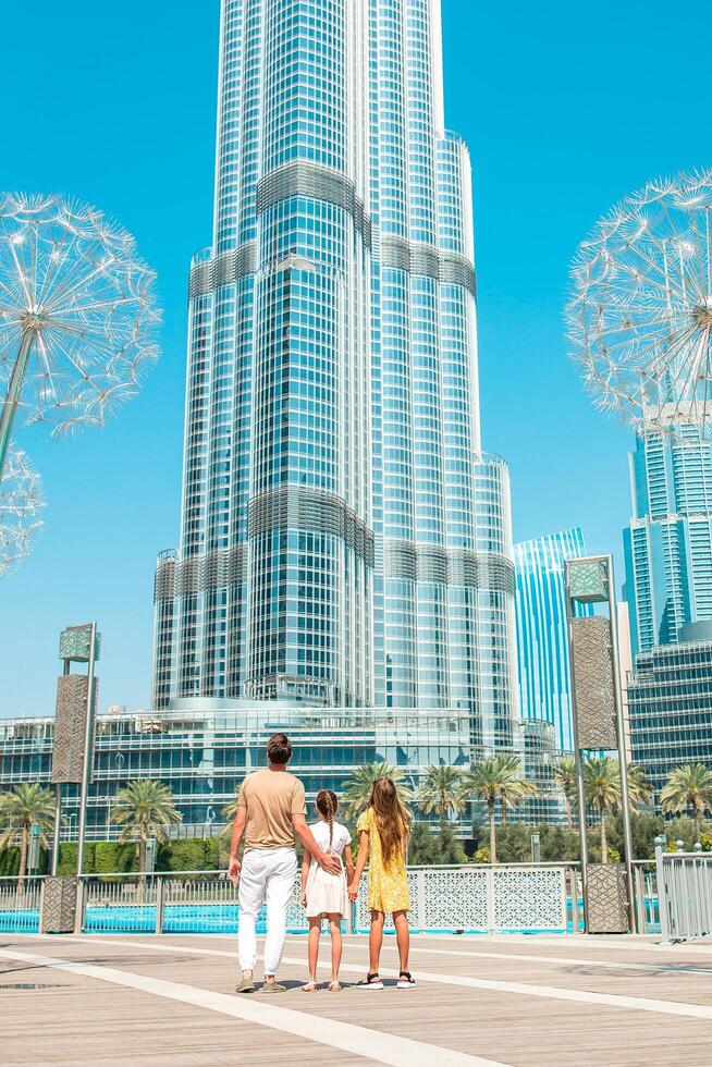 Happy family walking in Dubai with Burj Khalifa skyscraper in the background. photo