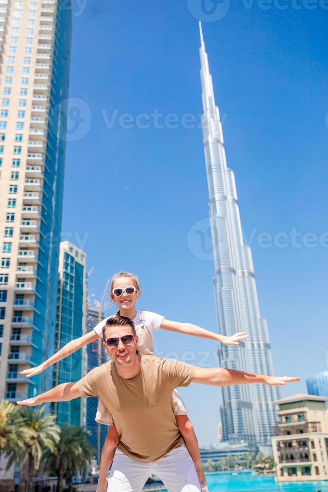 familia feliz caminando en dubai con rascacielos en el fondo. foto