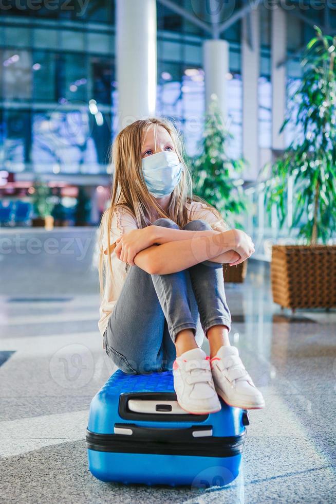 Little kid in medical mask in airport waiting for boarding photo