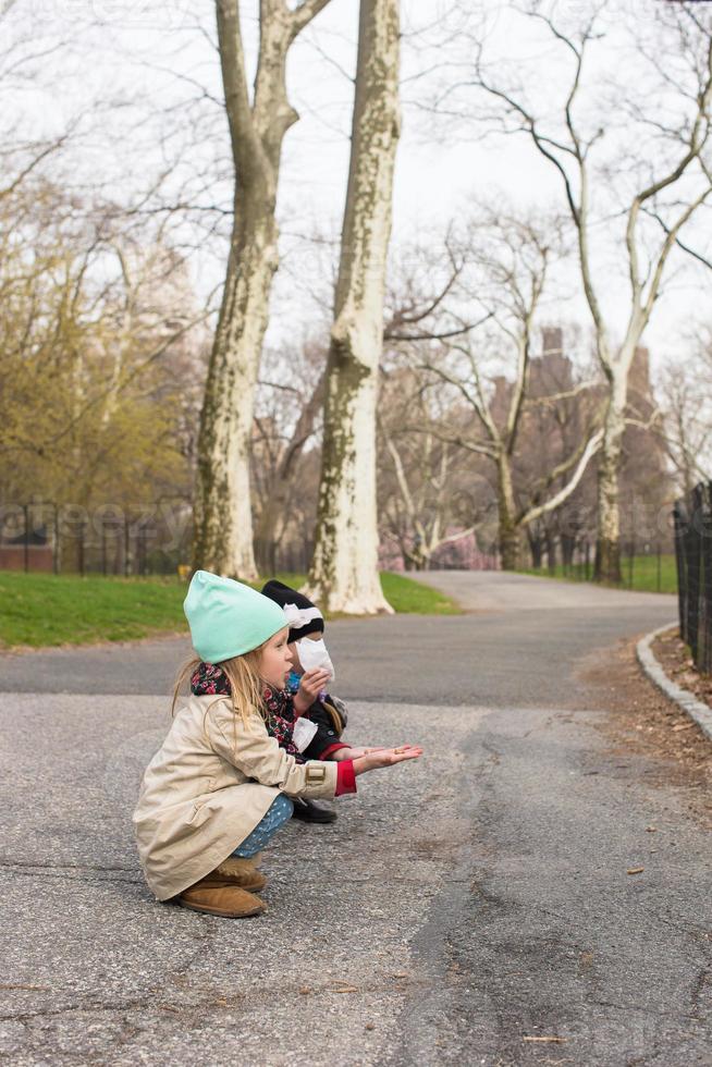 Little girls feeds a squirrel in Central park, New York, America photo