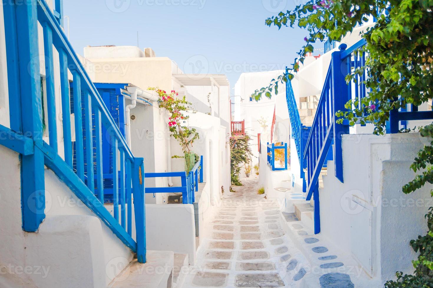 las estrechas calles de la isla con balcones azules, escaleras y flores. foto