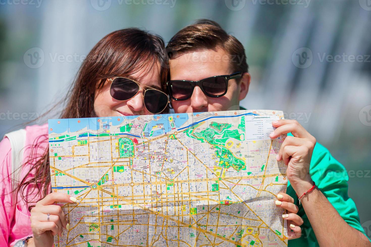 Young tourist friends traveling on holidays in Europe smiling happy. Closeup caucasian family with city map in search of attractions photo