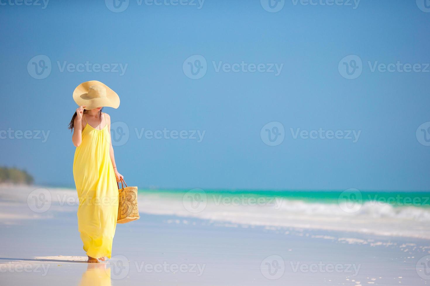 Young woman in hat during tropical beach vacation photo
