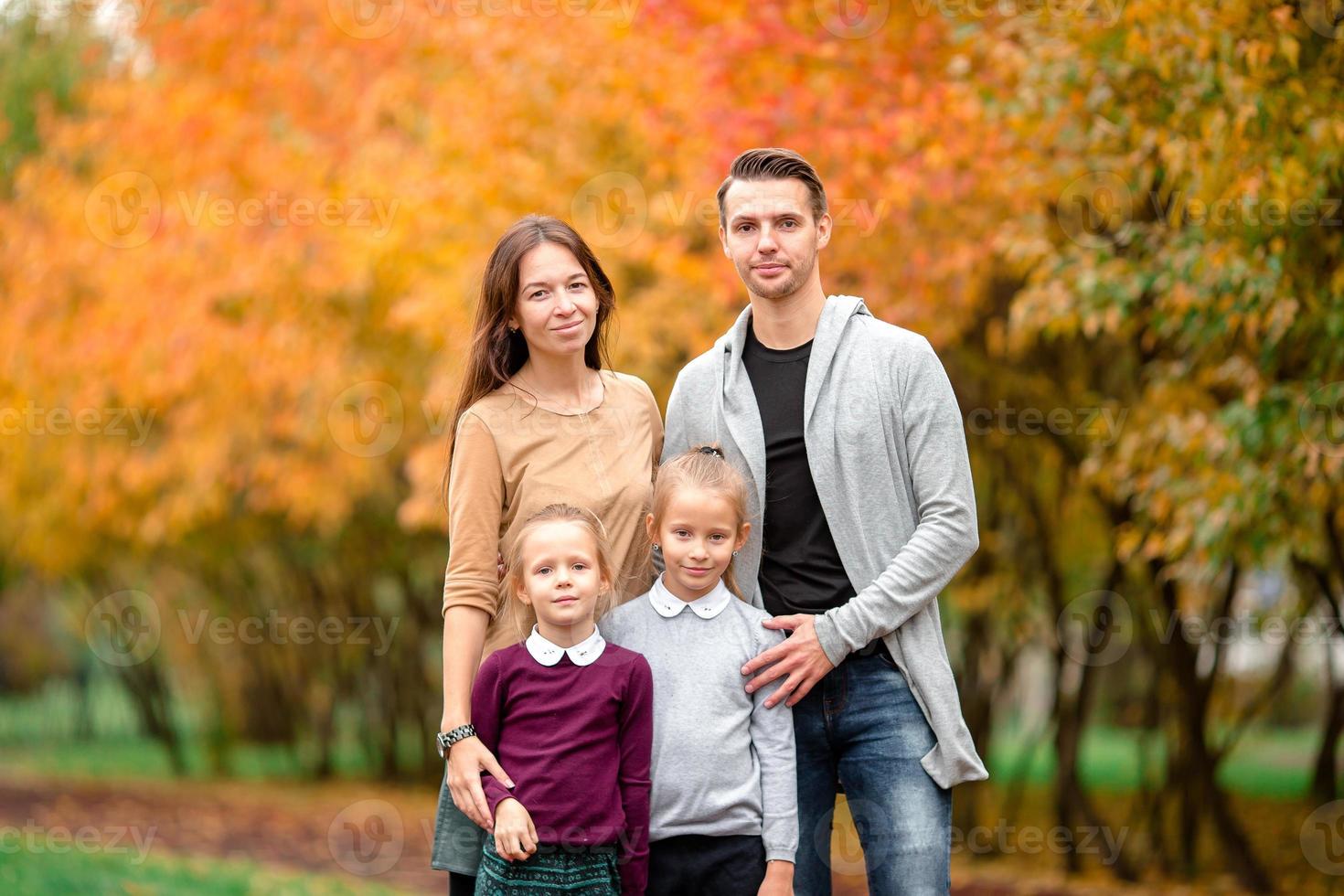 Portrait of happy family of four in autumn day photo