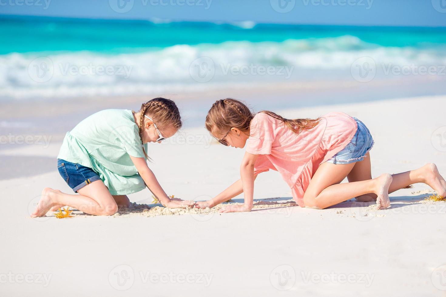 Adorable little kids play with white sand photo