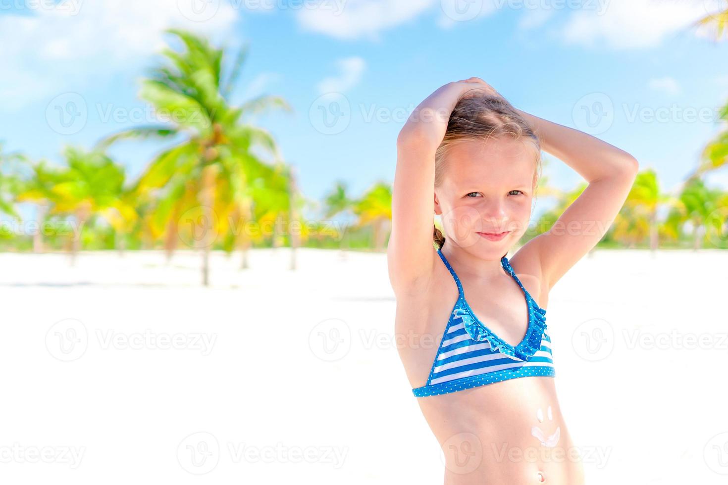 Beautiful little girl at beach having fun. Funny girl enjoy summer vacation. photo