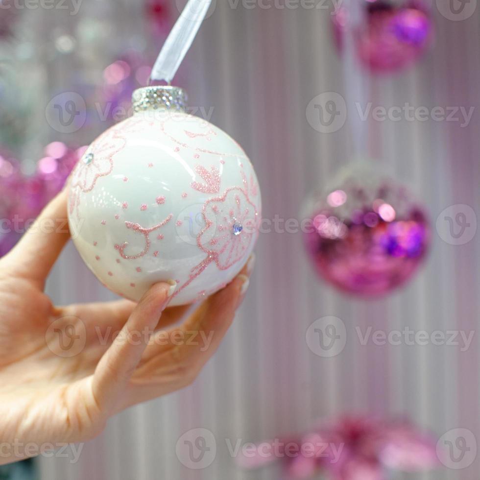 hermosa bola en el árbol de navidad en la mano foto