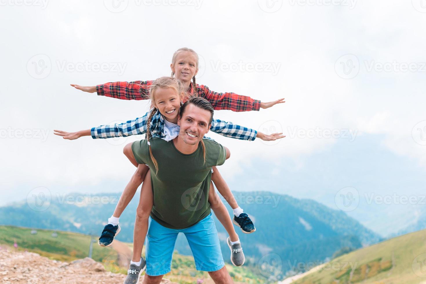 Beautiful kids and happy man in mountains in the background of fog photo