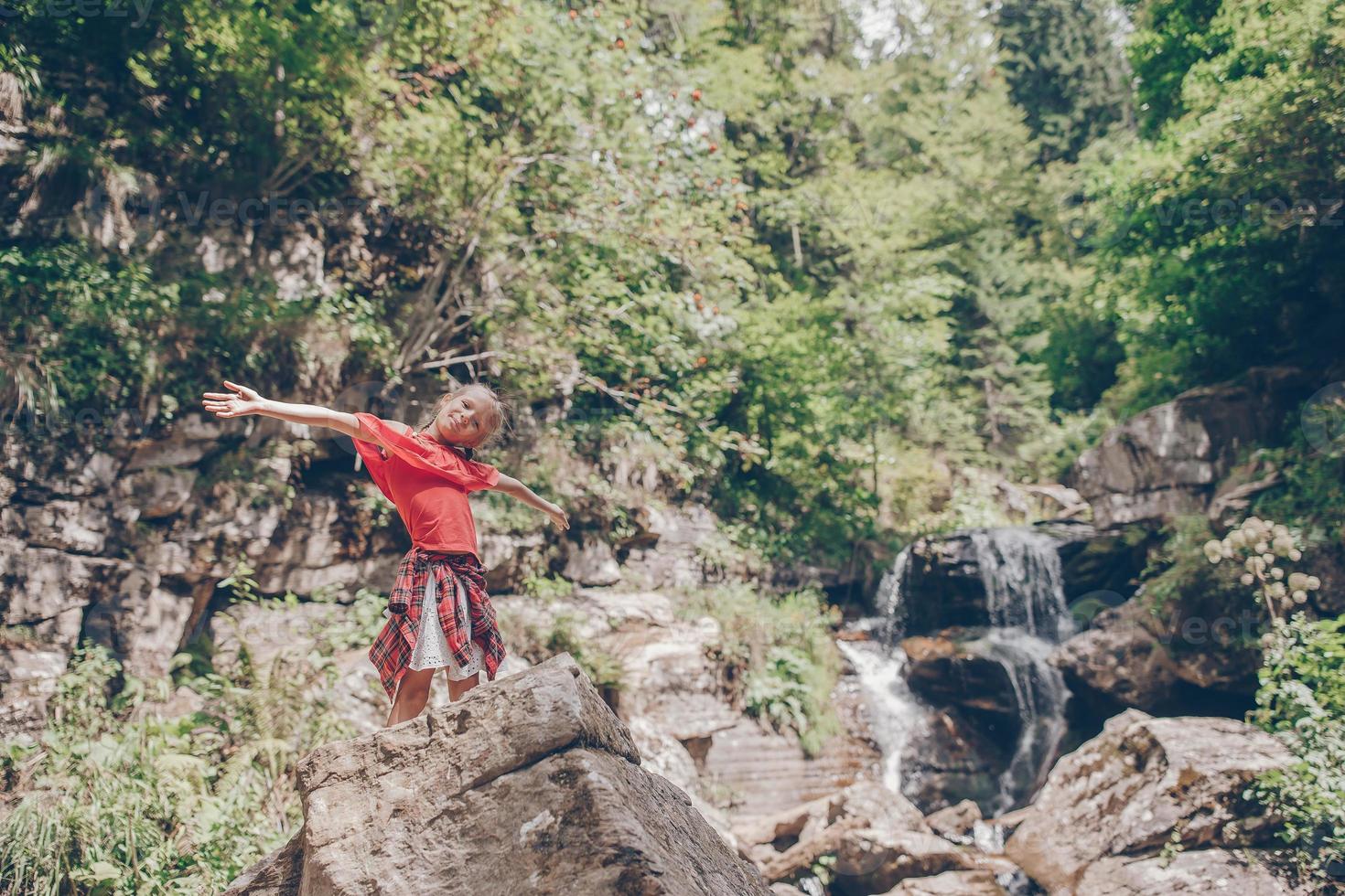 Little girl enjoying view of waterfall in Krasnay Poliana photo