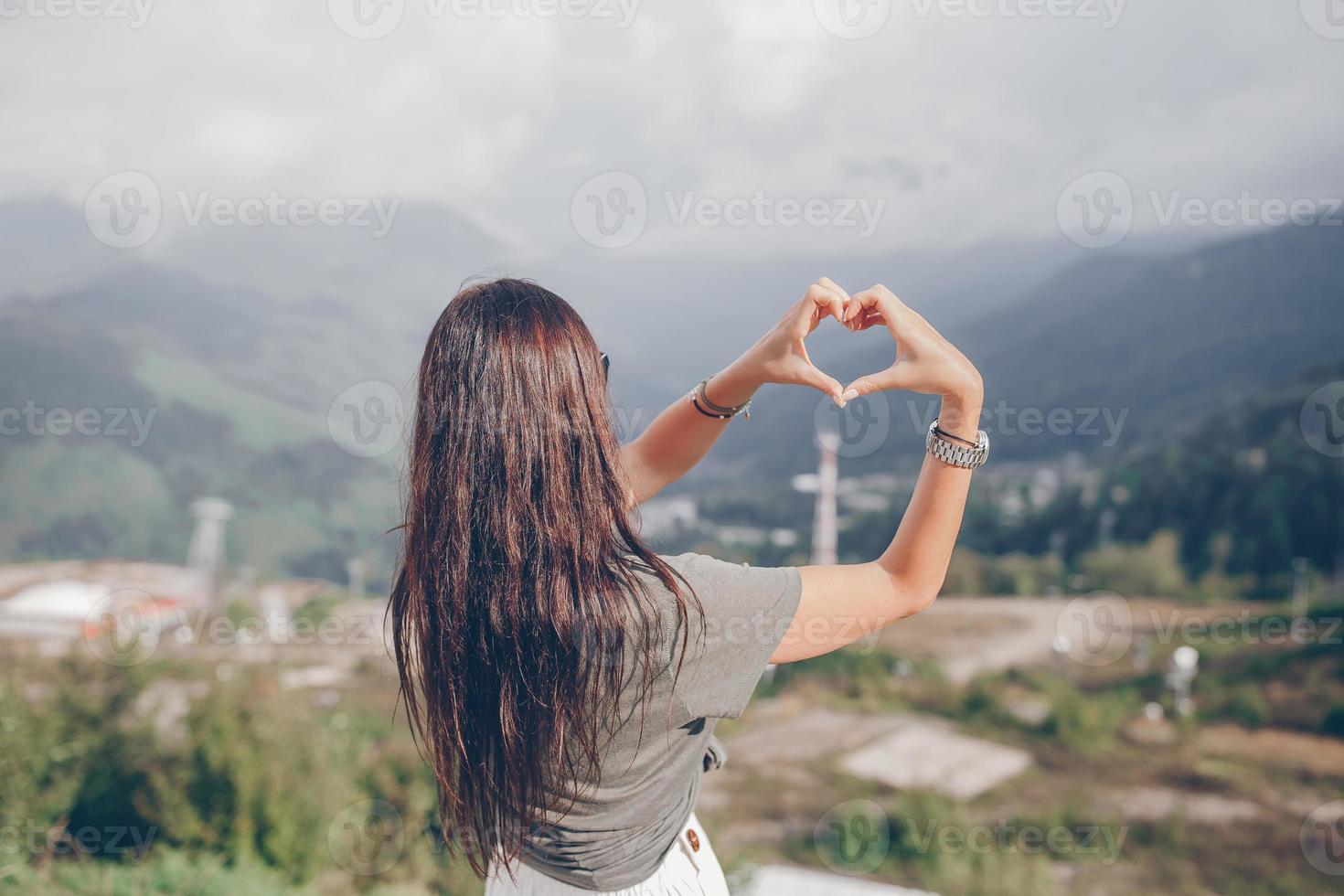 Beautiful happy young woman in mountains in the background of fog photo