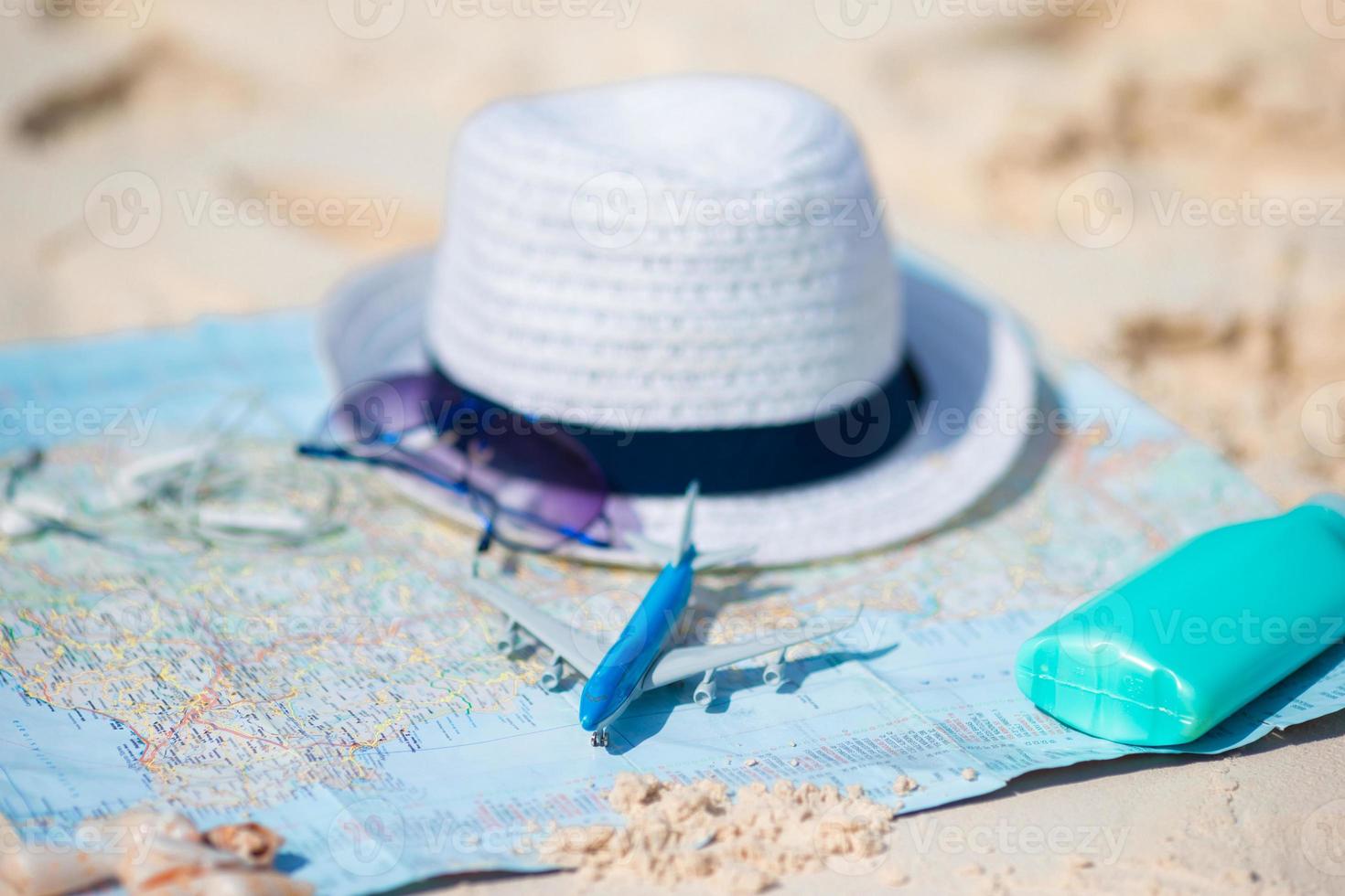 Traveling concept. Hat, suncream, sunglasses on a map of the world. photo