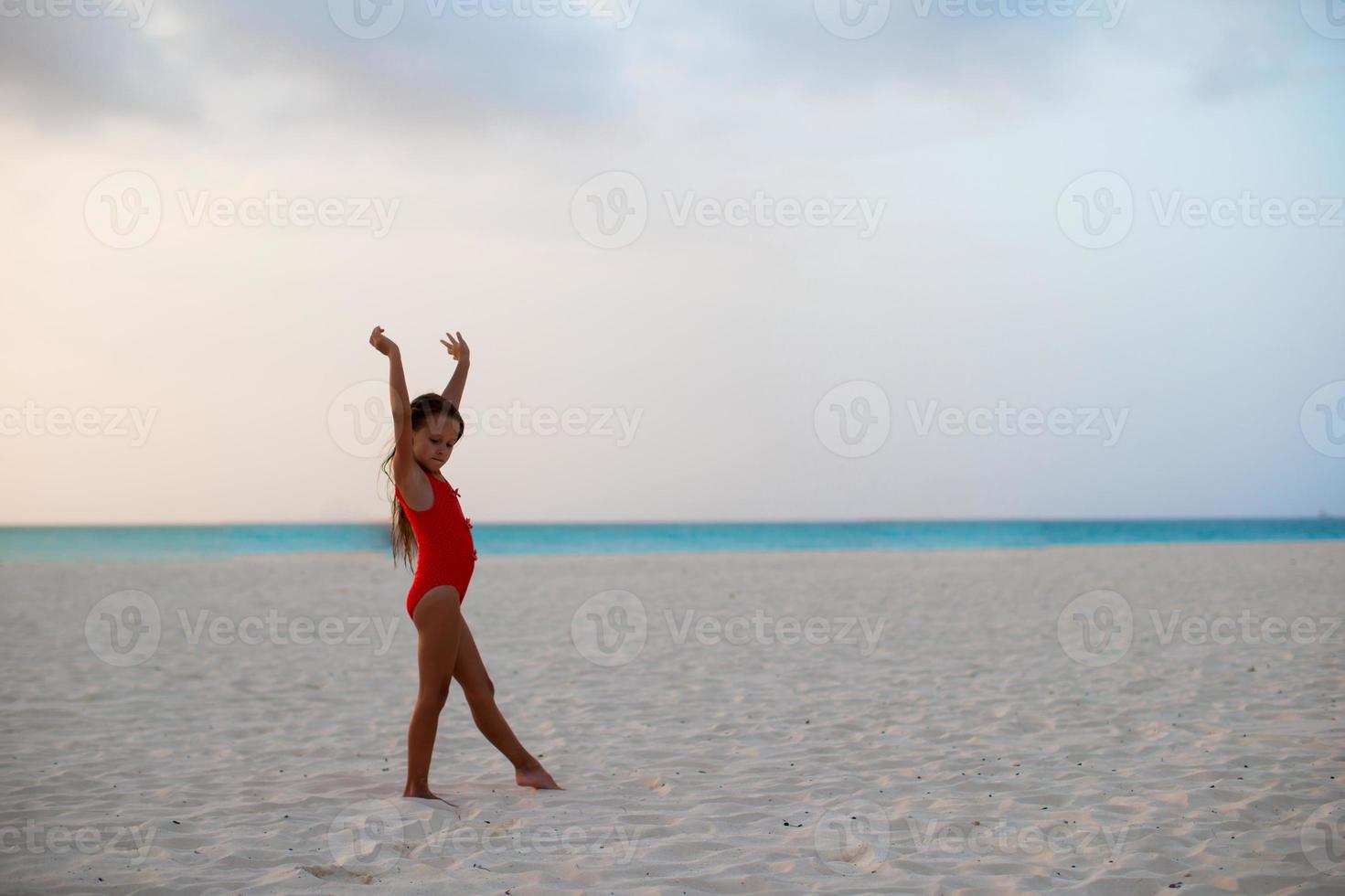 Adorable little girl during beach vacation having fun photo