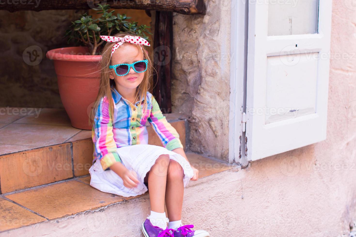 adorable niña en un café al aire libre en una ciudad europea foto