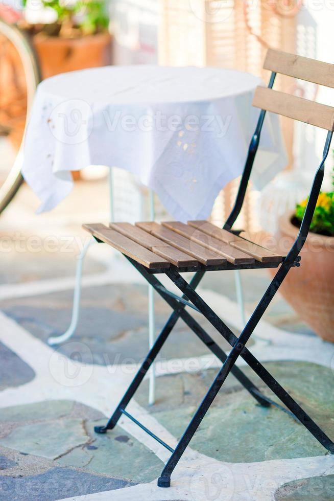 mesas blancas con silla en el café al aire libre vacío de verano en grecia foto