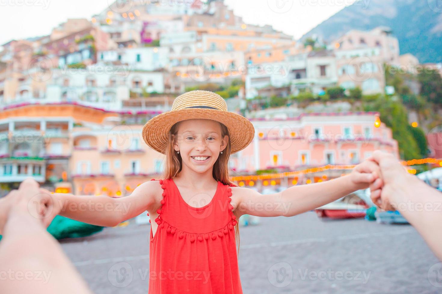 Adorable little girl on warm and sunny summer day in Positano town in Italy photo