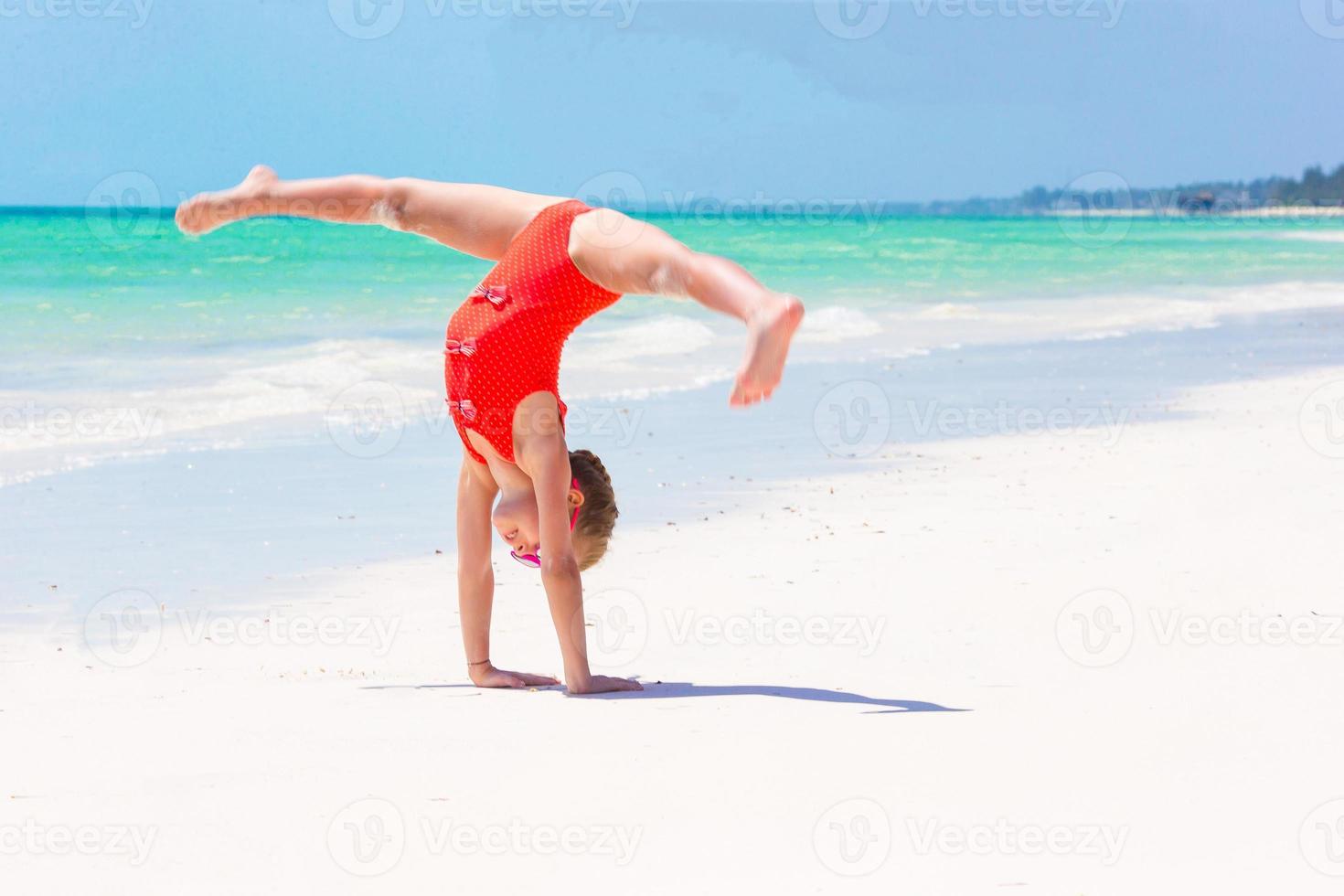 Active little girl on white beach having fun. Closeup kid background the sea photo