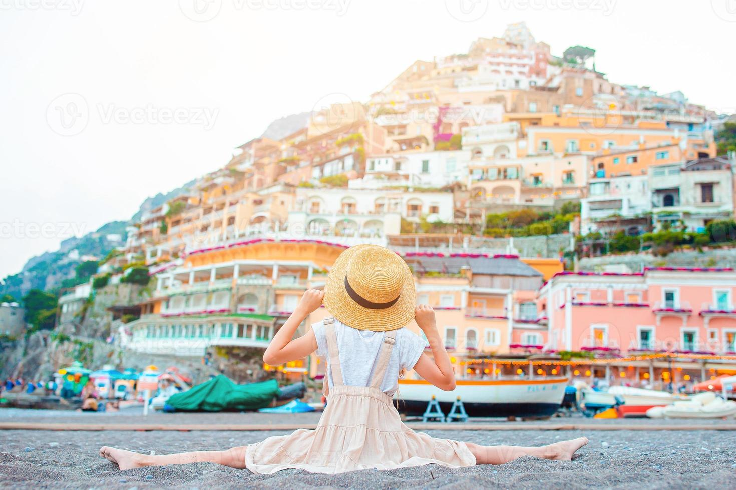 Adorable little girl on warm and sunny summer day in Positano town in Italy photo