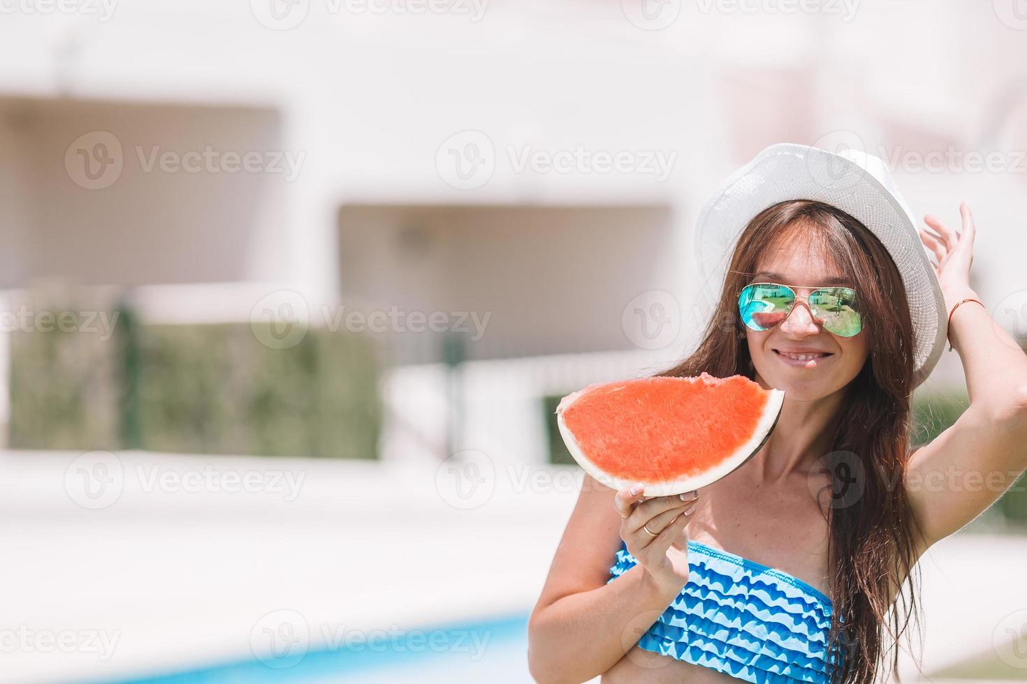 mujer joven con sandía relajante al aire libre en vacaciones de verano foto