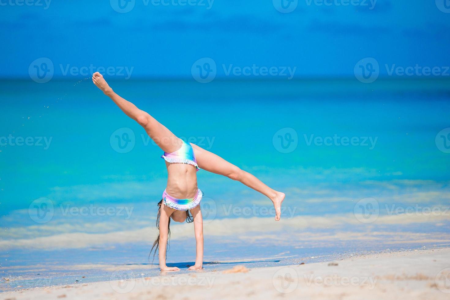 adorable niña activa en la playa durante las vacaciones de verano foto