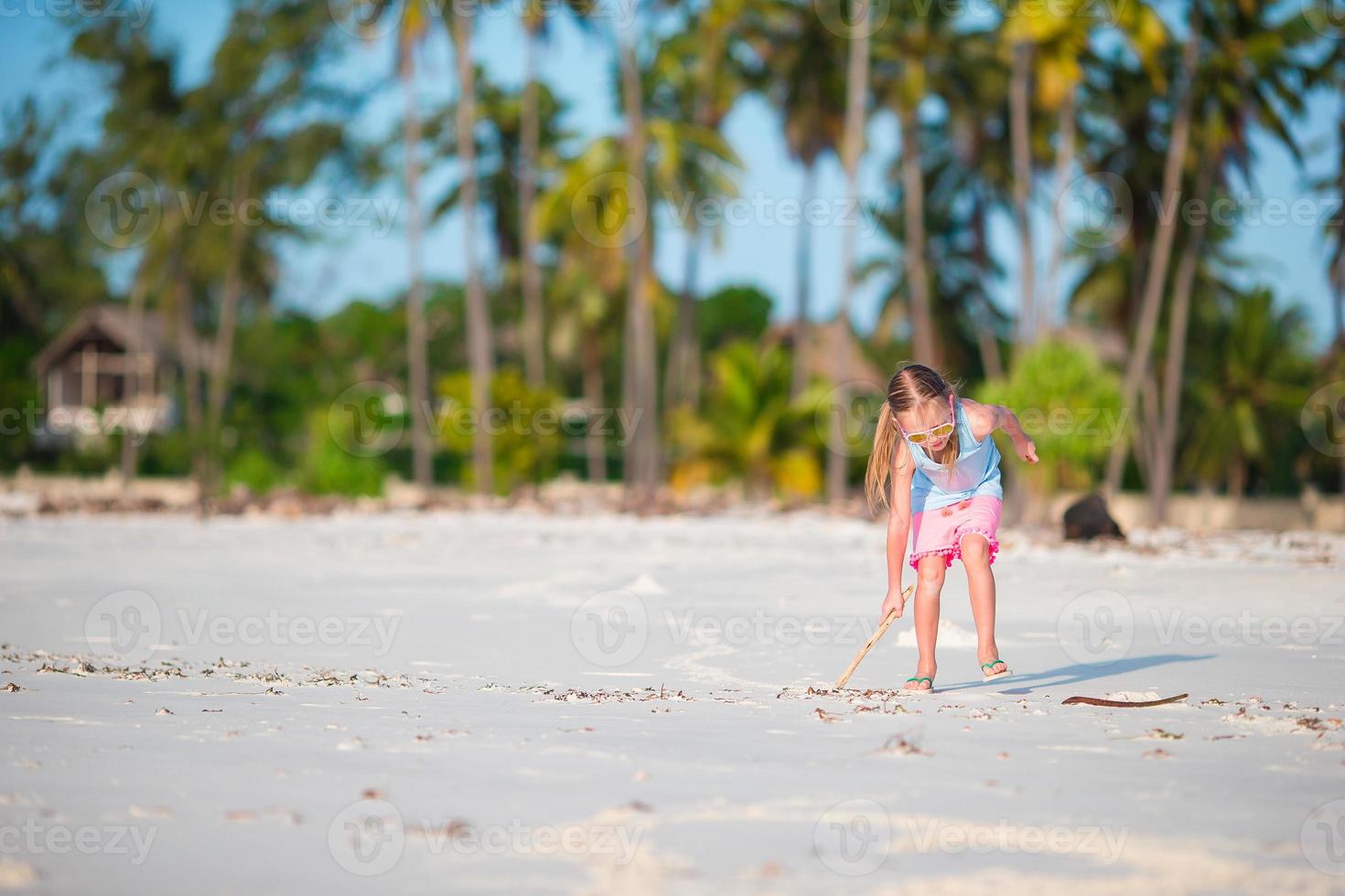 Active little girl on white beach having fun. Closeup kid background the sea photo