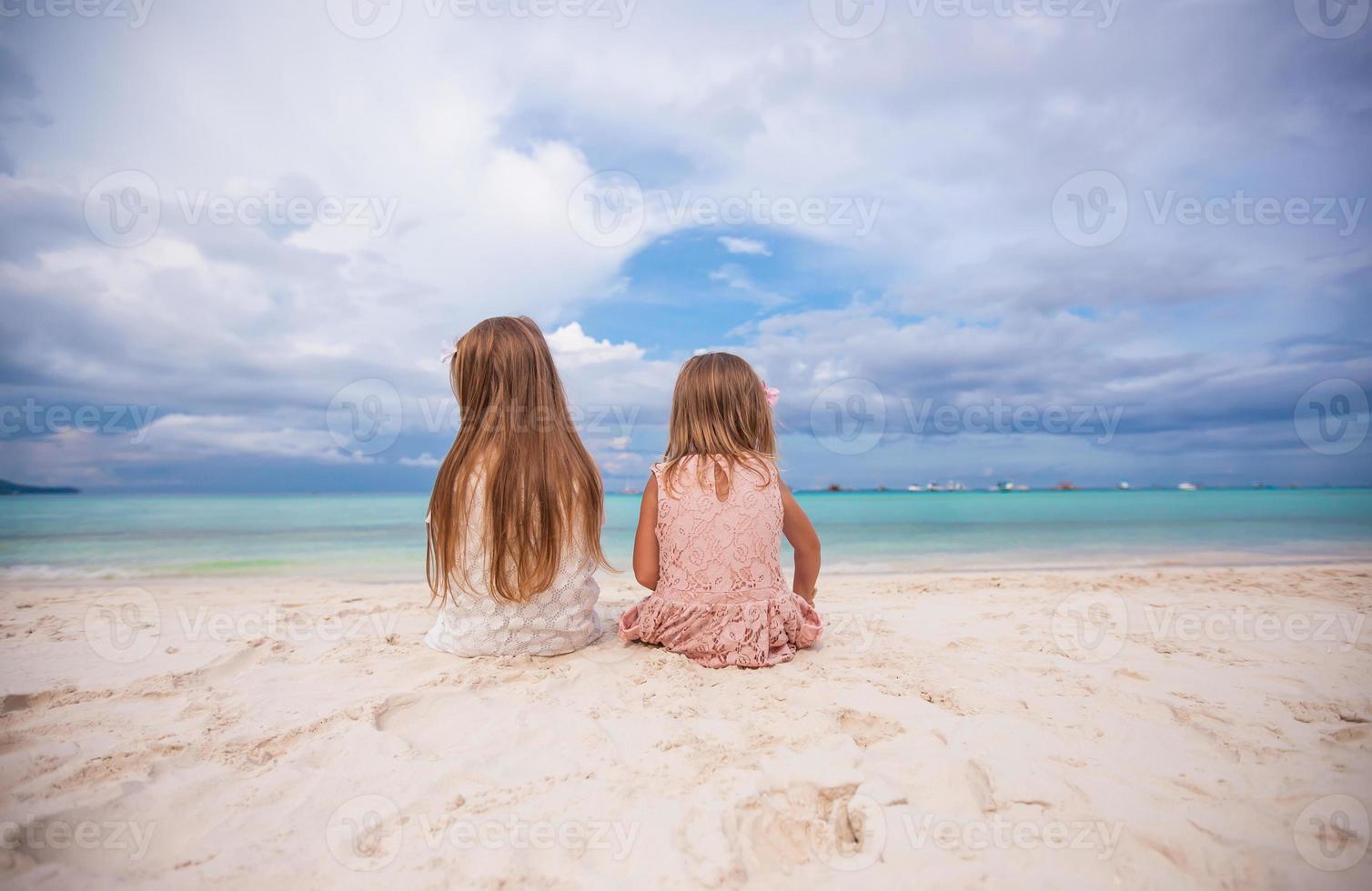 Adorable little girls at beach during summer vacation photo