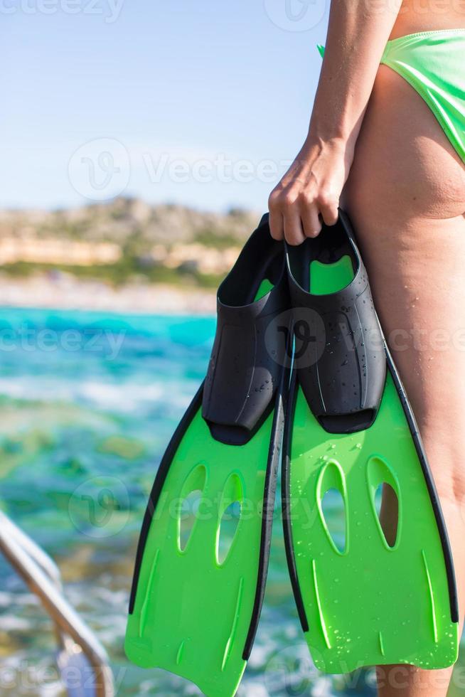 Diving goggles, snorkel and snorkeling fins at woman hands photo