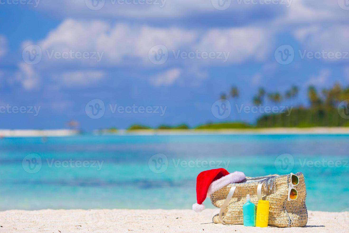 Beach accessories with Santa Hat on white tropical beach photo