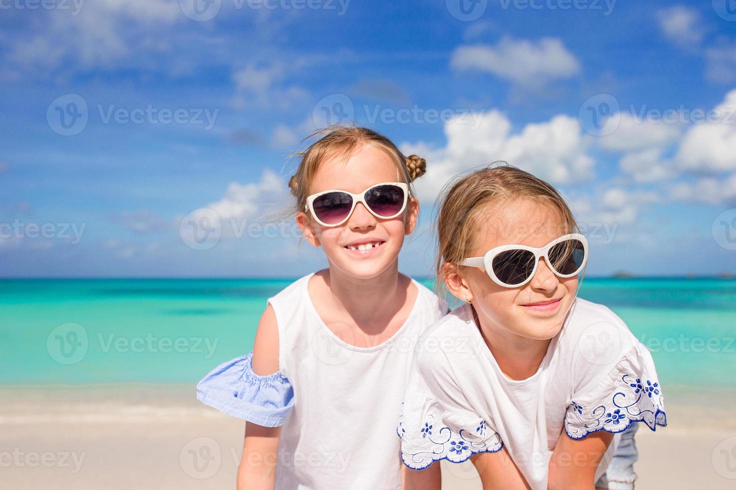 Portrait of two beautiful kids looking at camera background of beautiful nature of blue sky and turquoise sea photo