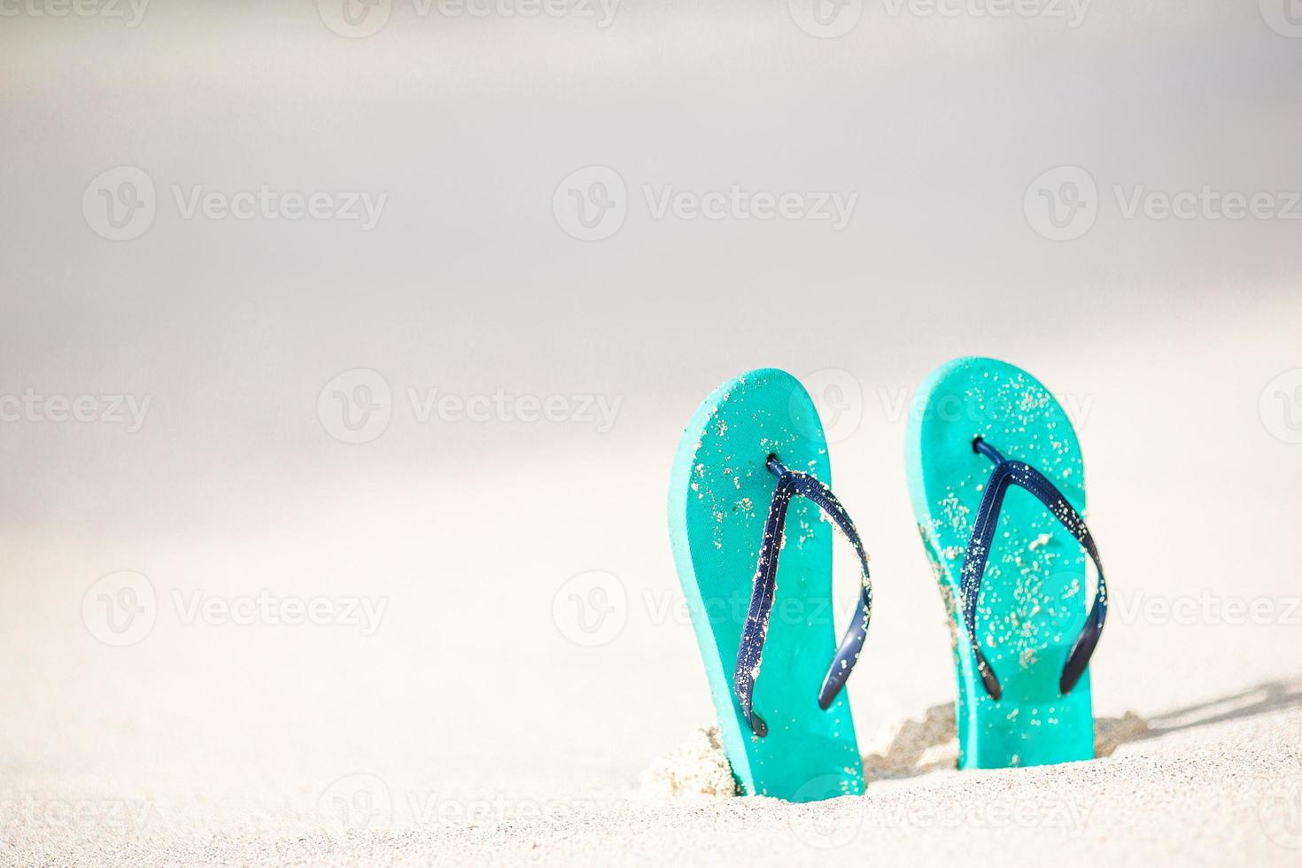 Summer mint flip flops with sunglasses on white beach photo