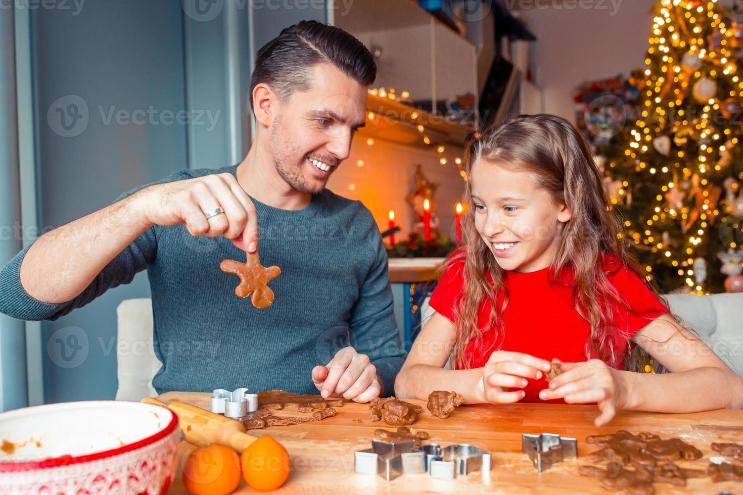 familia horneando galletas de jengibre en vacaciones de navidad foto