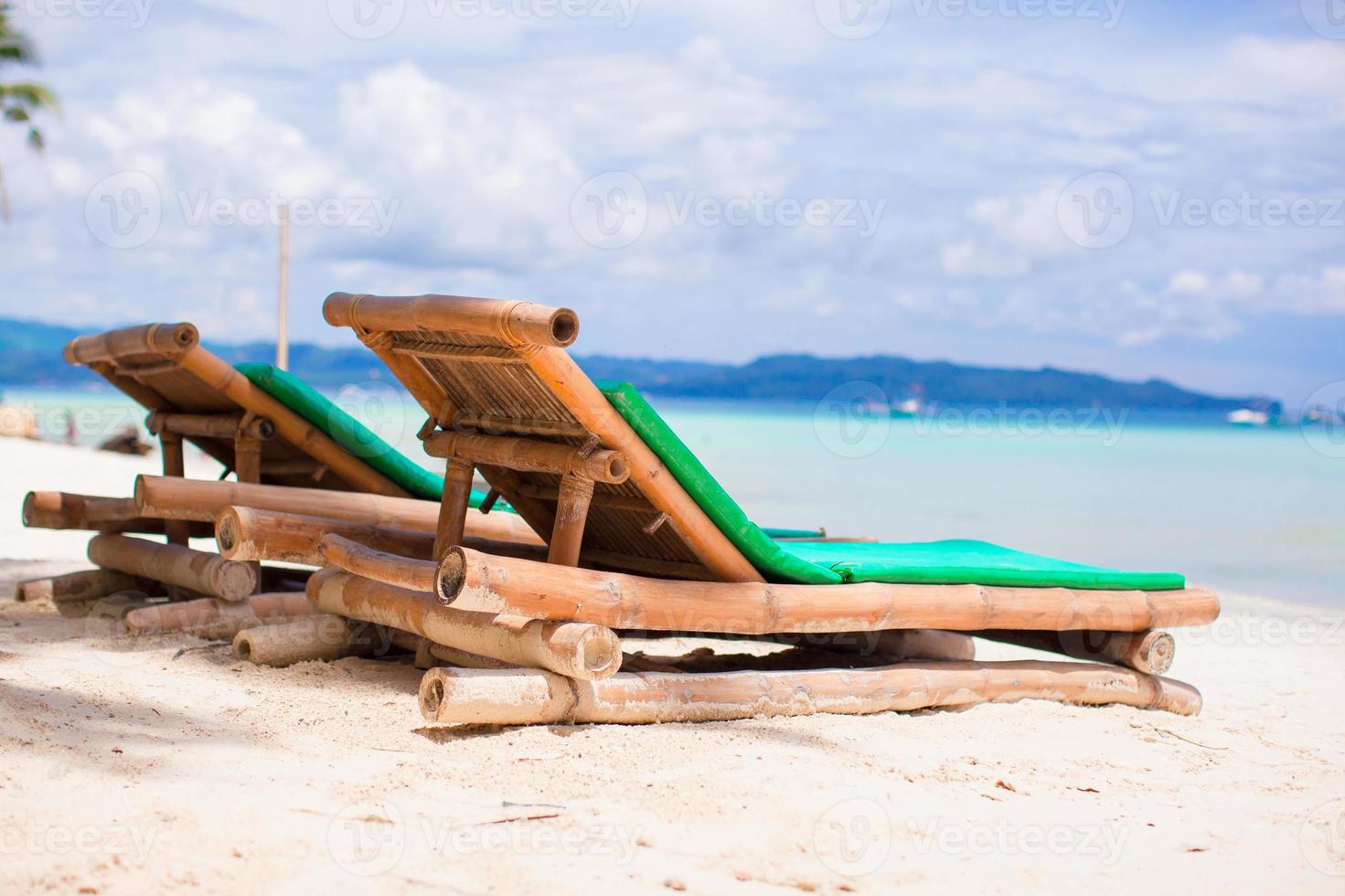 Beach chairs on exotic tropical white sandy beach photo